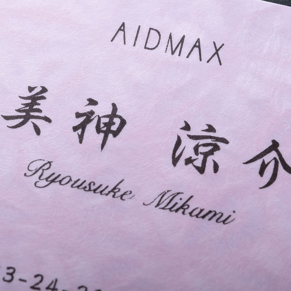 和の文様で美しく彩られたピンクの和紙素材に筆文字をあしらった品のある和紙名刺。No.7204